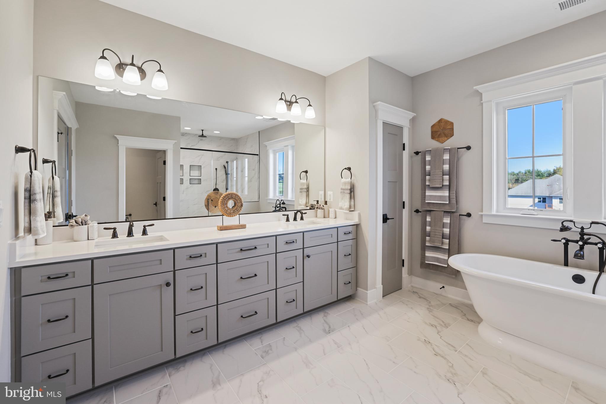 17628 Bates Drive Hamilton, VA 20158 - Photo 45 of 57 a spacious bathroom with a double vanity sink a large mirror and a bathtub