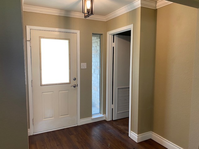 1002 Creekbend Cove Pflugerville, TX 78660 - Photo 9 of 16 Foyer entrance featuring dark wood-type flooring and crown molding