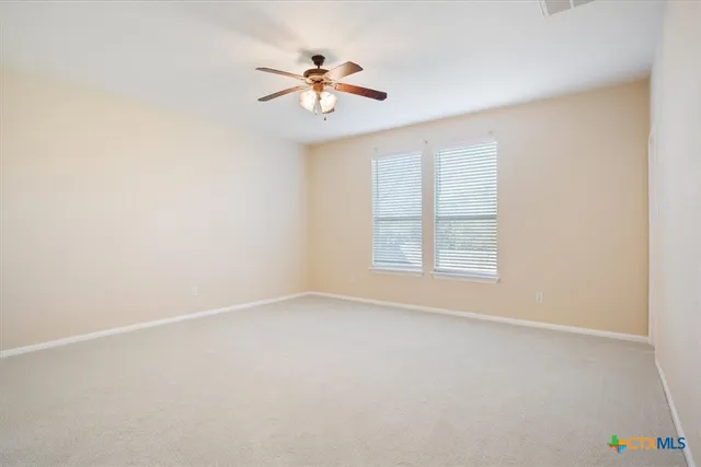 an empty room with a window and a fan
