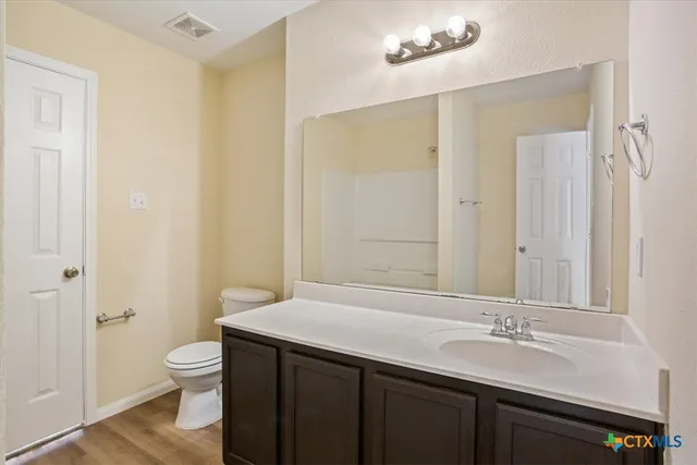 a bathroom with a granite countertop sink toilet a large mirror and shower
