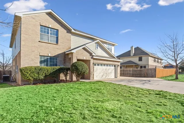 a front view of a house with a yard and potted plants