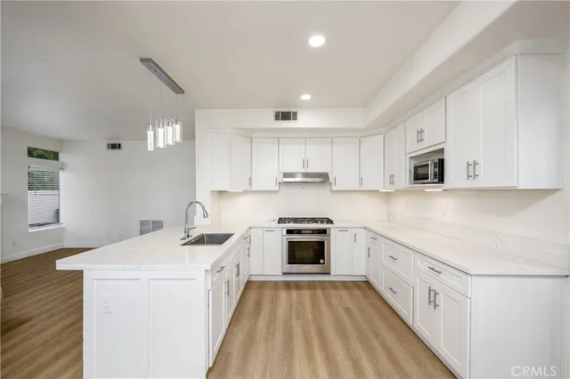 a kitchen with cabinets stainless steel appliances a sink and a counter top space