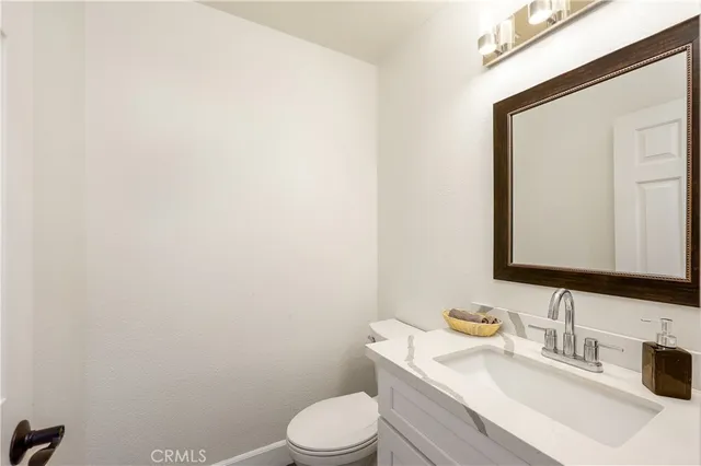 a bathroom with a toilet sink vanity and mirror