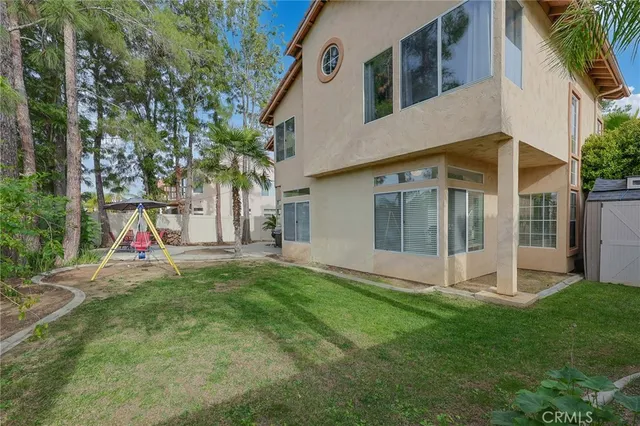 a view of a house with a yard and tree s