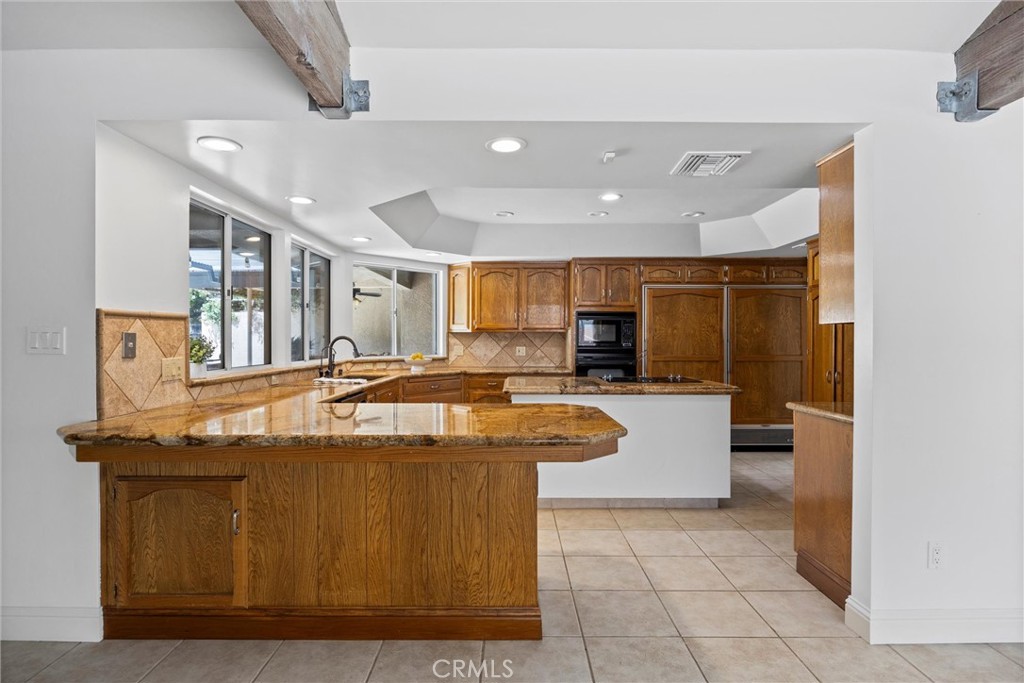11717 Old Town Road Bakersfield, CA 93312 - Photo 27 of 61 a view of a kitchen with kitchen island a sink a stove and a refrigerator with wooden floor