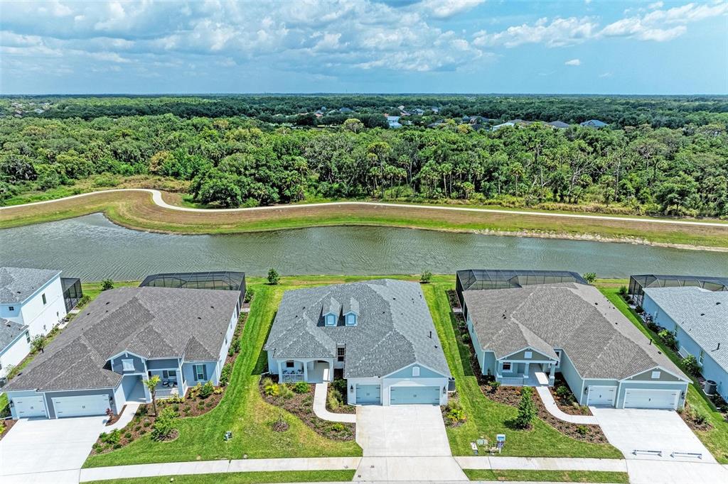 14359 Skipping Stone Loop Parrish, FL 34219 - Photo 2 of 71 an aerial view of a house with a garden and lake view
