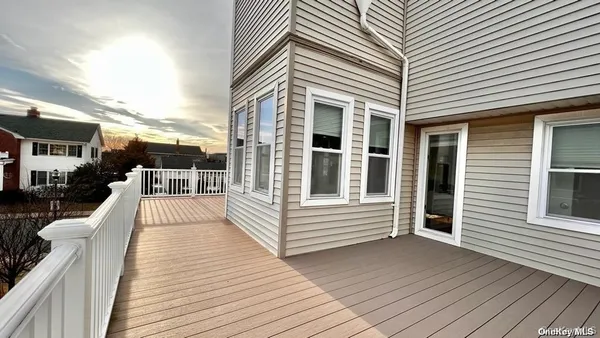 a view of a house with barbeque and wooden floor