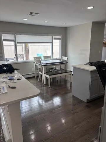 a kitchen with stainless steel appliances granite countertop a stove and a view of living room