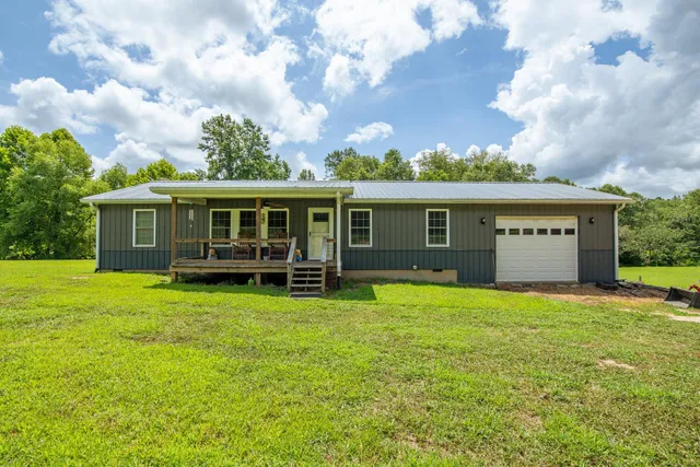 a view of a house with a yard and sitting area