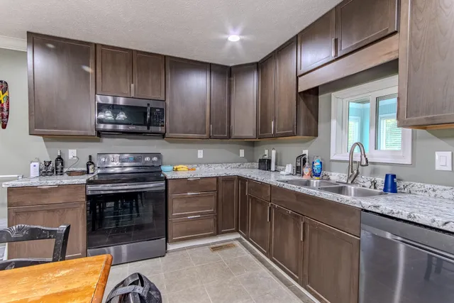 a kitchen with stainless steel appliances granite countertop a stove sink microwave and cabinets