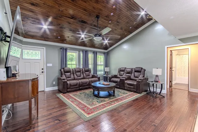a living room with furniture and a wooden floor