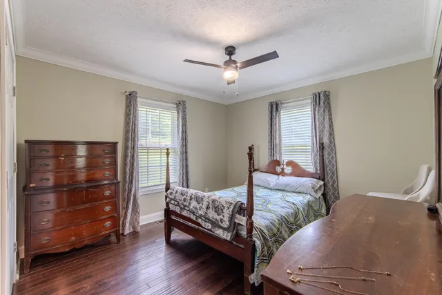 a bedroom with two beds and ceiling fan