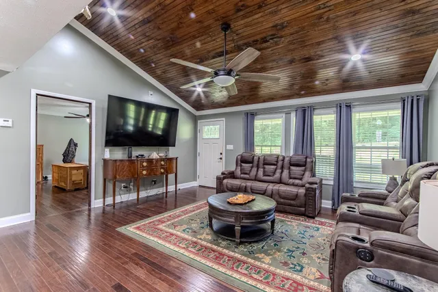 a living room with furniture a flat screen tv and a chandelier