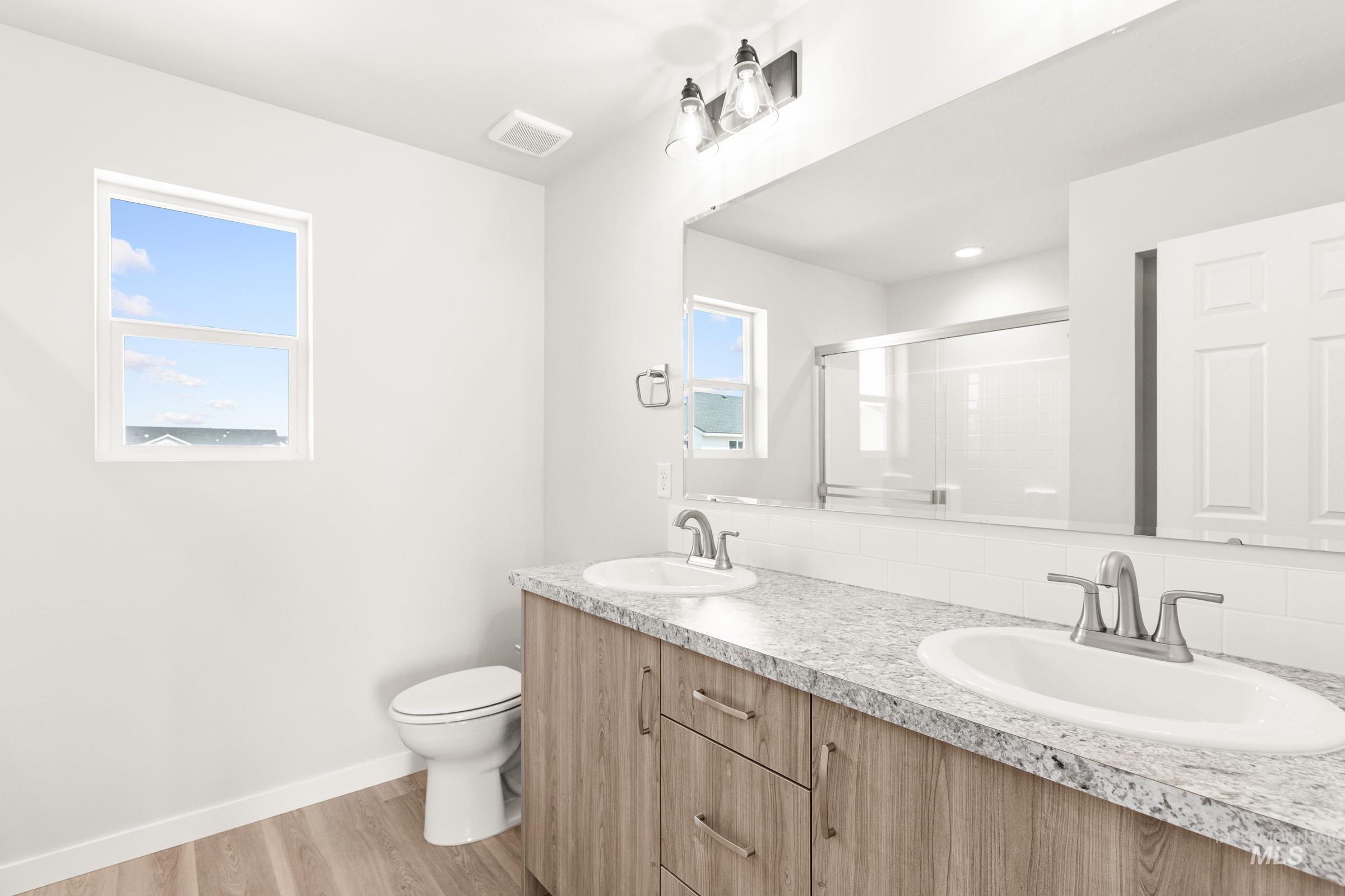 13716 Redway Court Caldwell, ID 83607 - Photo 10 of 18 Bathroom with double vanity, a shower stall, and light wood-type flooring