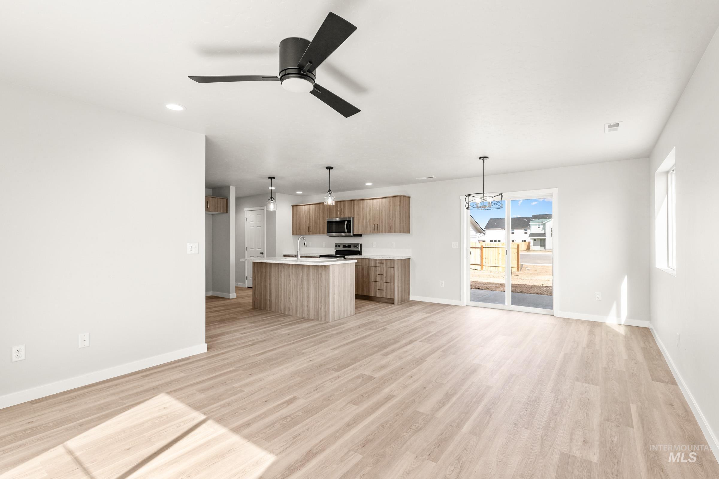 13716 Redway Court Caldwell, ID 83607 - Photo 17 of 18 Kitchen with open floor plan, light countertops, an island with sink, light wood-type flooring, and a ceiling fan