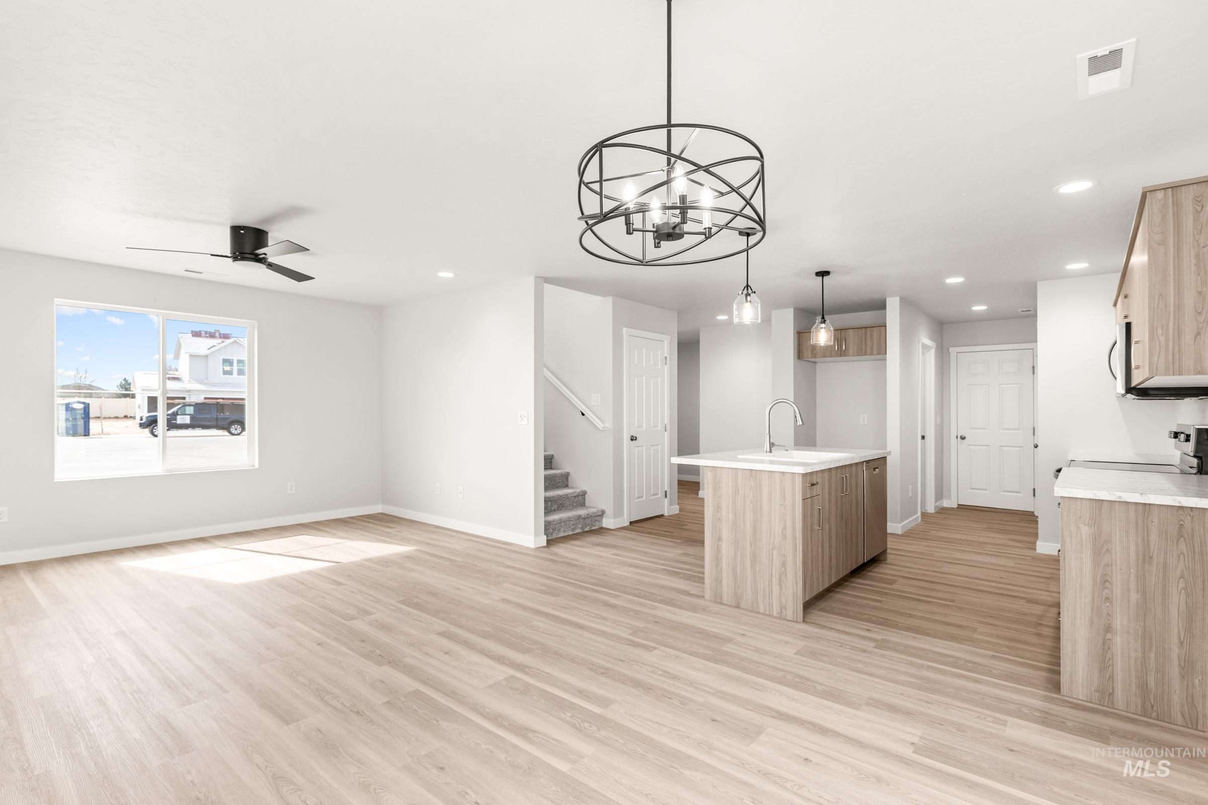 13716 Redway Court Caldwell, ID 83607 - Photo 18 of 18 Kitchen featuring open floor plan, a kitchen island with sink, a ceiling fan, electric range, and light wood-style floors