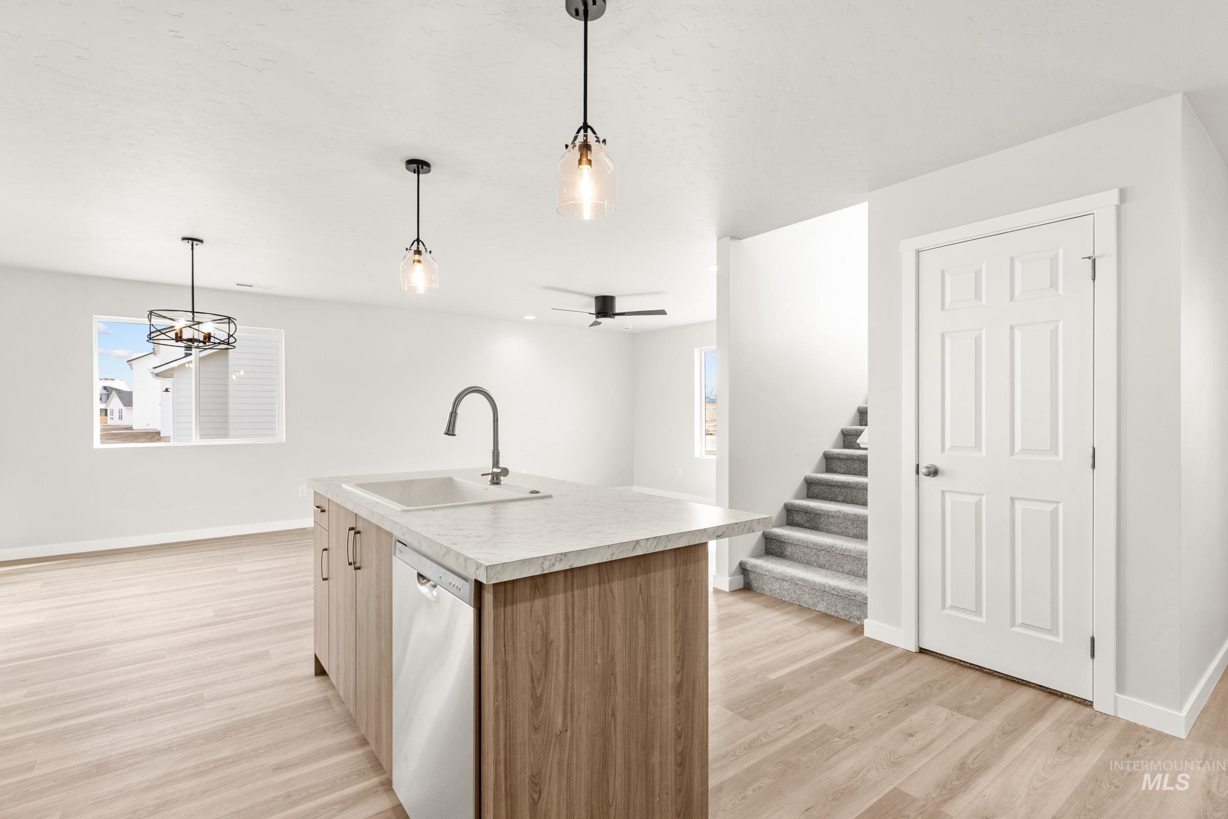 13716 Redway Court Caldwell, ID 83607 - Photo 8 of 18 Kitchen featuring a kitchen island with sink, light countertops, stainless steel dishwasher, light wood finished floors, and ceiling fan