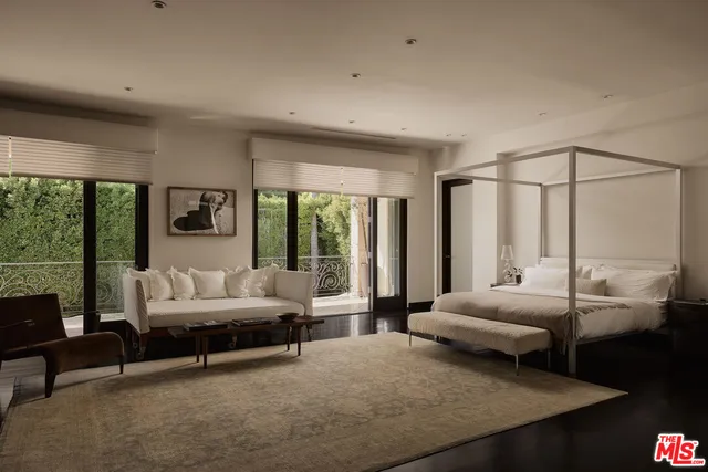 a bedroom with furniture and large windows