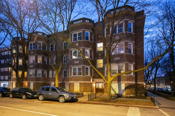 a front view of a residential apartment building with a yard