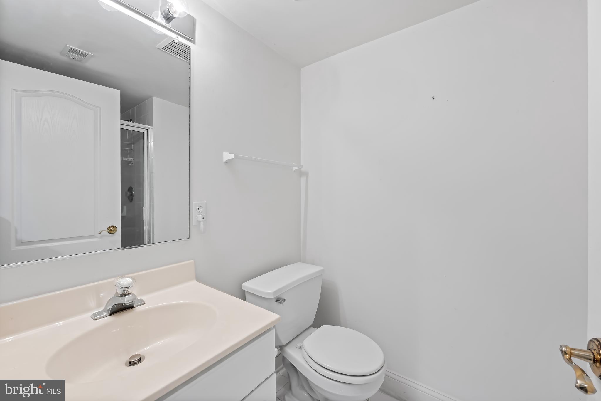 24 Roland Green, Unit 12 Baltimore, MD 21210 - Photo 38 of 53 a bathroom with a toilet a sink and mirror