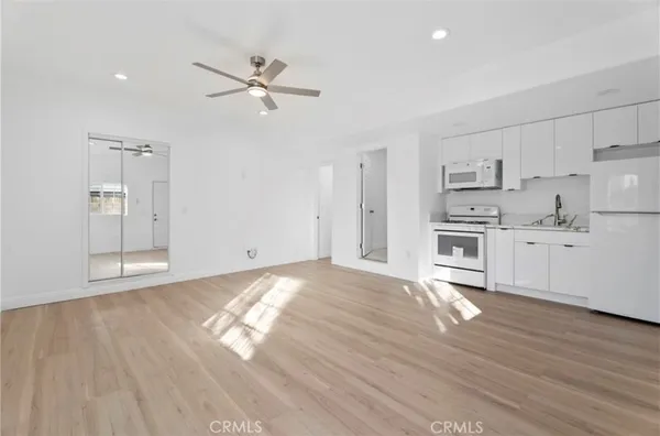 a view of empty room with wooden floor and window