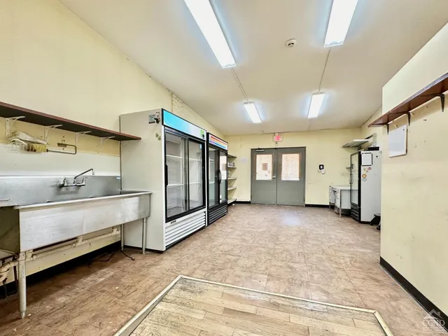 a view of an empty room with window and cabinet