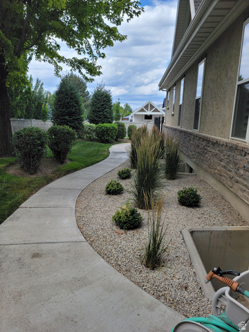 650 East Center Street Alpine, UT 84004 - Photo 33 of 38 Manicured landscaping featuring a curved concrete pathway and a gravel bed with ornamental grasses and shrubs