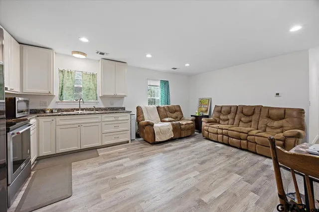 a living room with furniture and kitchen