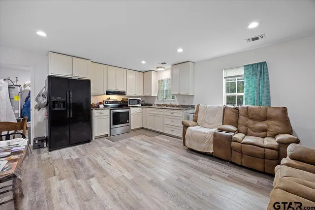 a kitchen with a refrigerator and a couch