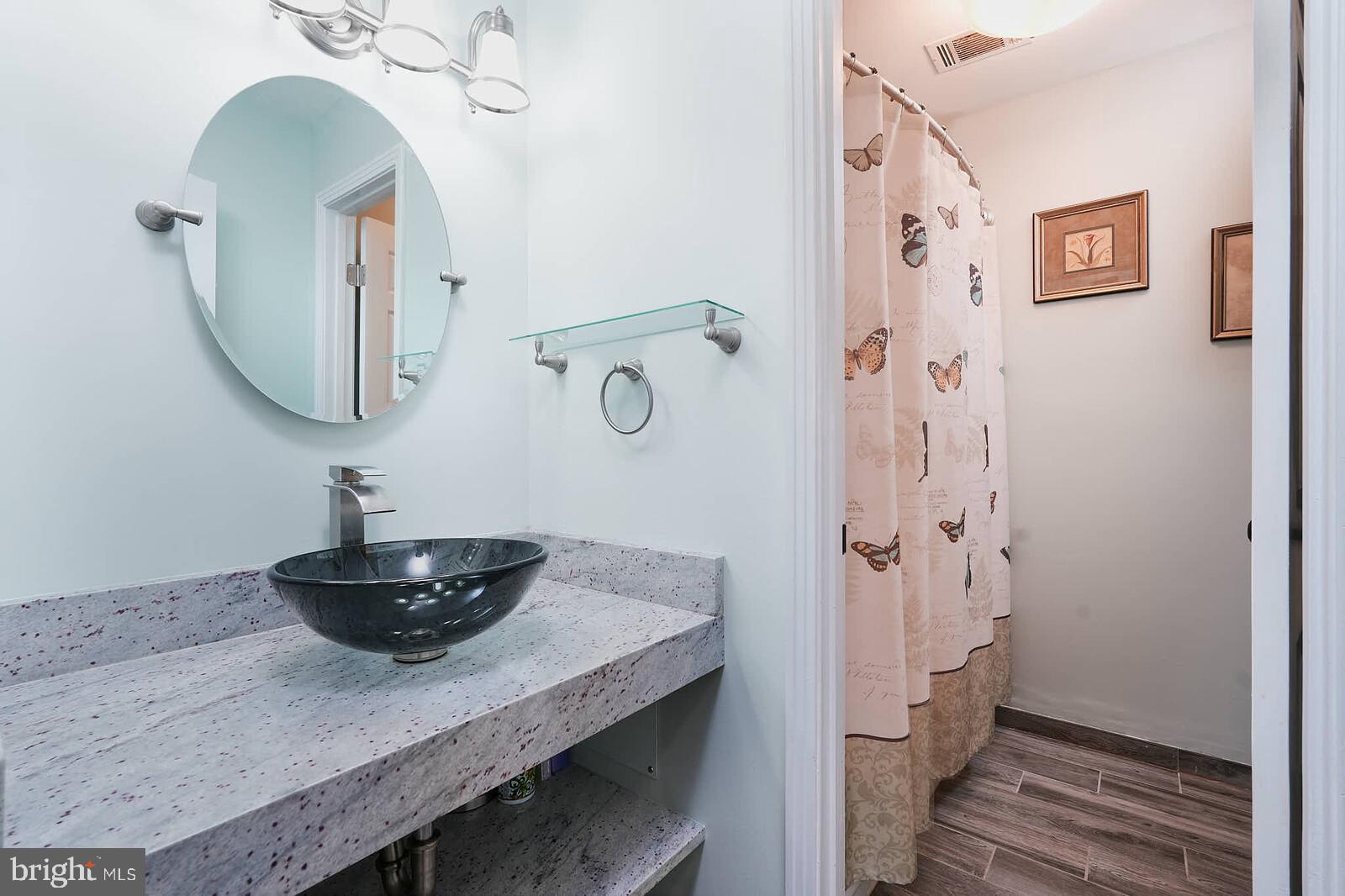 9505 Columbia Boulevard Silver Spring, MD 20910 - Photo 28 of 55 a bathroom with a granite countertop sink a shower and a mirror