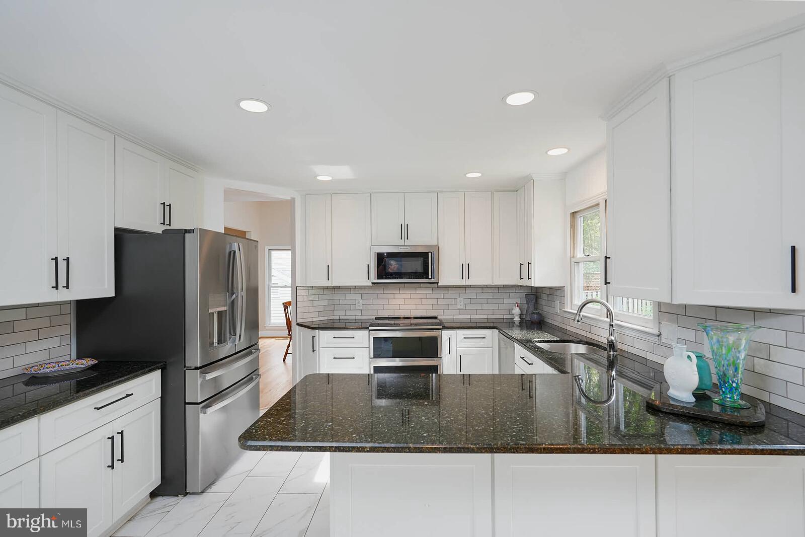 9505 Columbia Boulevard Silver Spring, MD 20910 - Photo 4 of 55 a kitchen with kitchen island granite countertop a sink a stove a refrigerator and cabinets