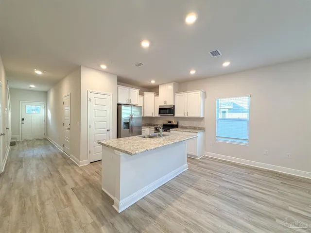 a view of kitchen with sink microwave and refrigerator