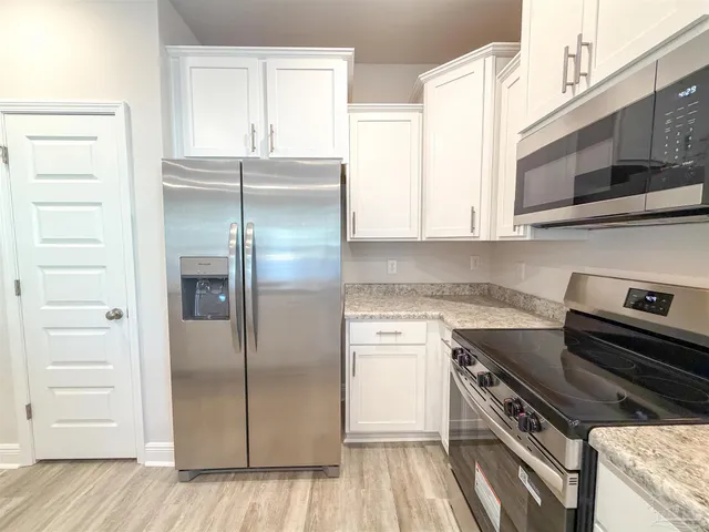 a kitchen with a refrigerator stove and cabinets