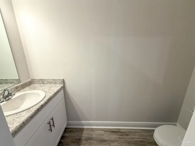 a bathroom with a granite countertop toilet and a sink