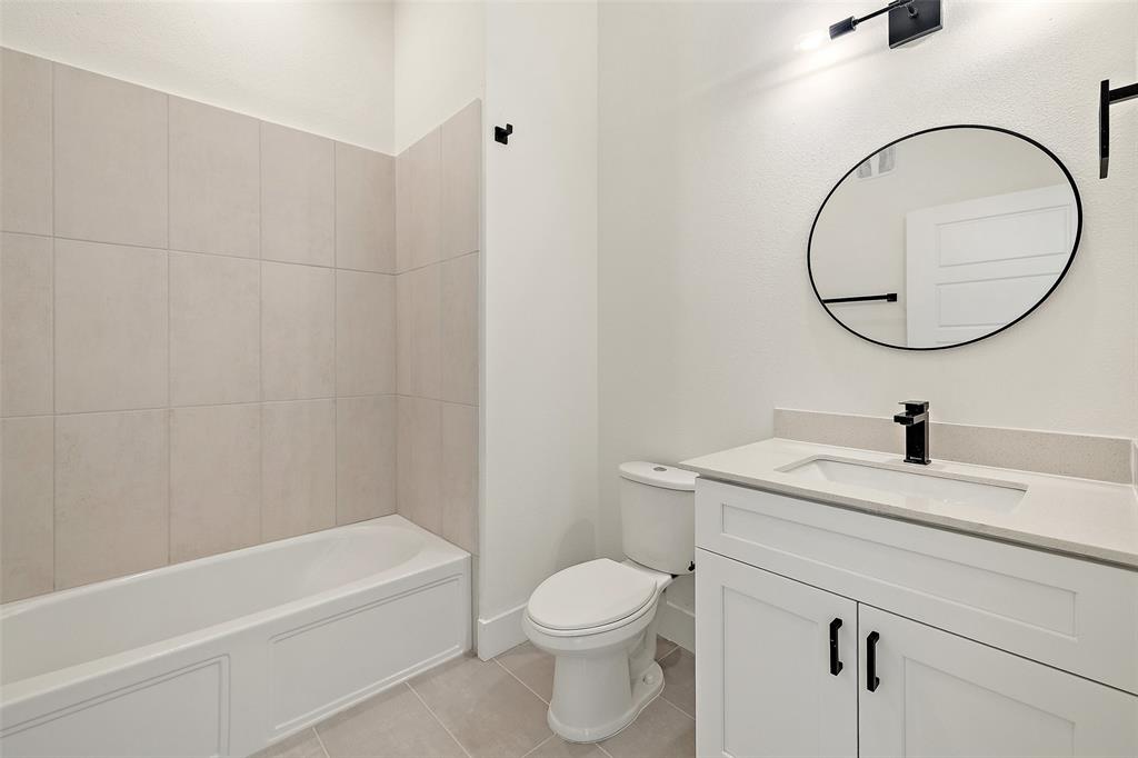 1811 Webberville Road, Unit 1305 Austin, TX 78721 - Photo 14 of 15 a bathroom with a granite countertop toilet a sink and a mirror