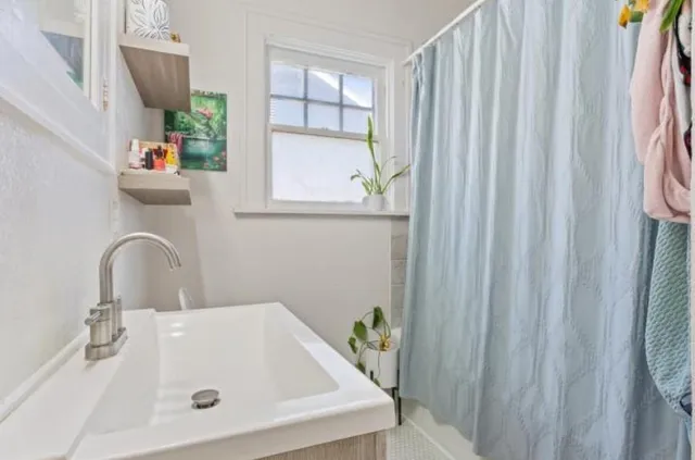a bathroom with a sink a mirror and a window