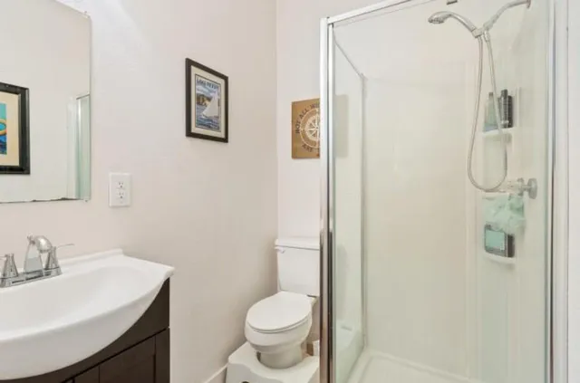 a bathroom with a granite countertop sink toilet and shower