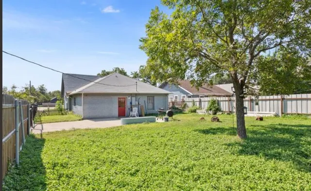 a front view of a house with a yard and trees