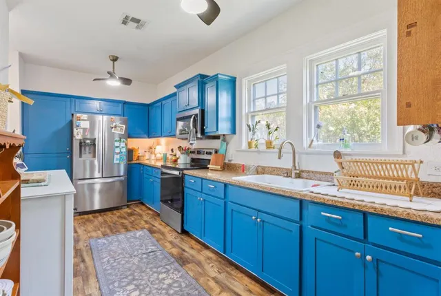 a kitchen with stainless steel appliances granite countertop a refrigerator stove and sink