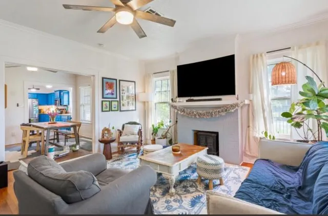 a living room with furniture a fireplace and a flat screen tv