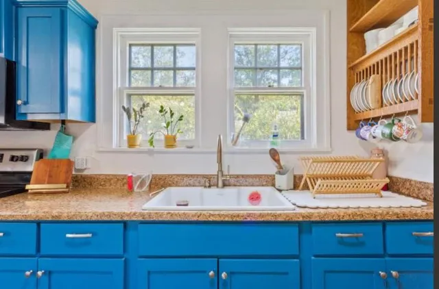 a bathroom with a granite countertop sink and a window