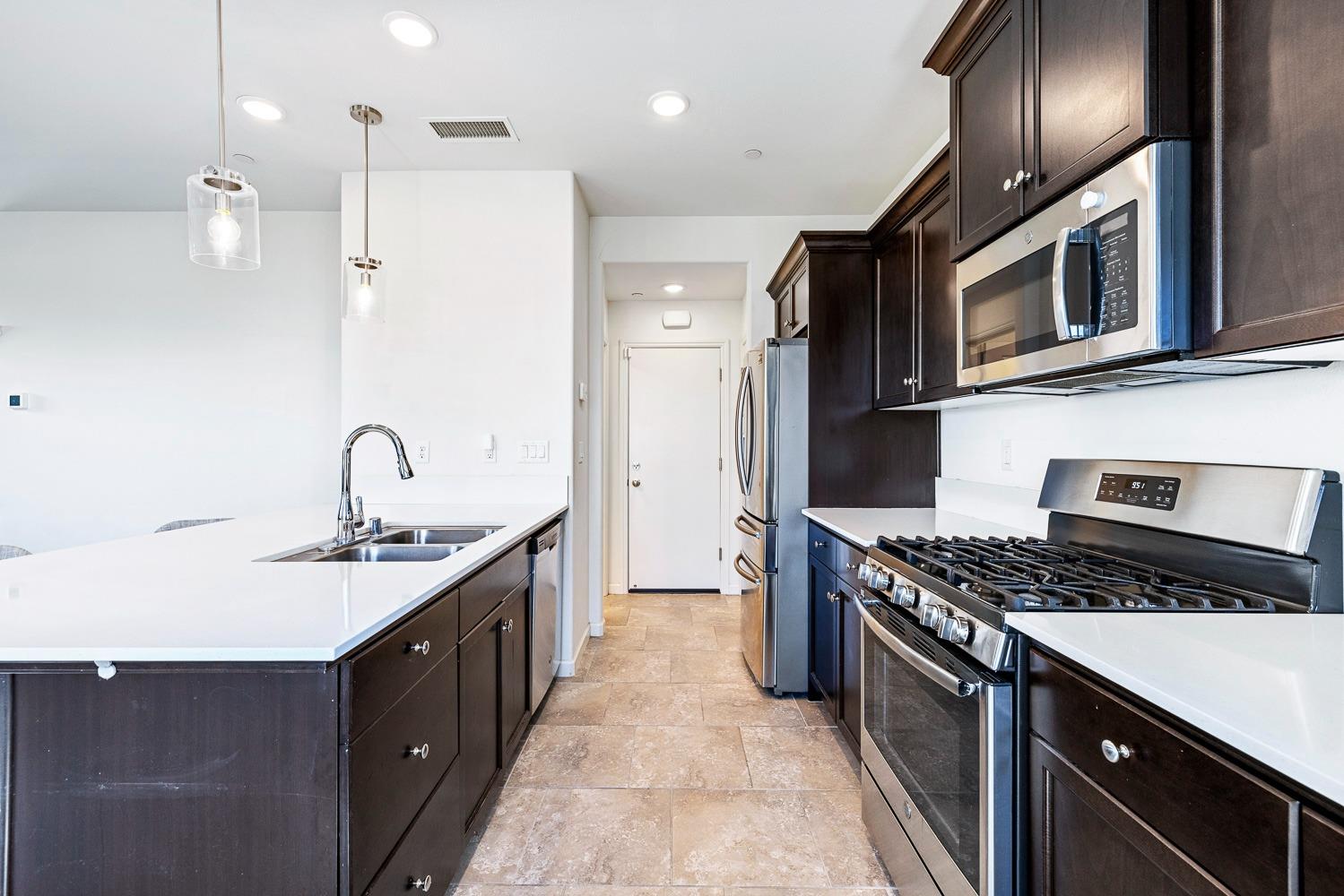 3606 Parkstone Way Clovis, CA 93619 - Photo 11 of 38 a kitchen with stainless steel appliances granite countertop a sink a stove and a refrigerator
