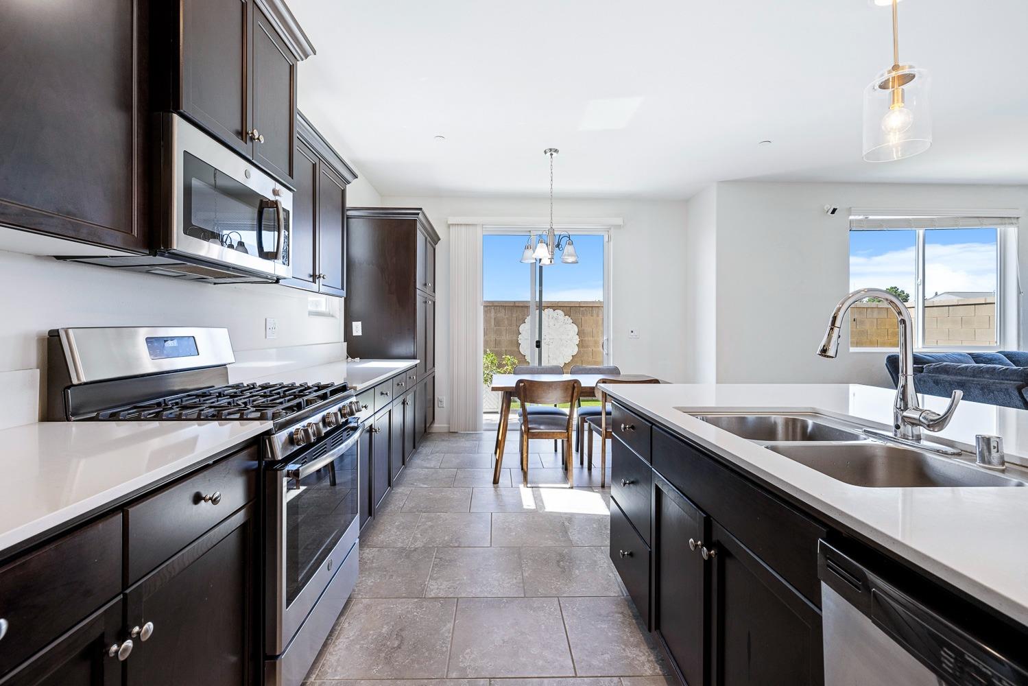 3606 Parkstone Way Clovis, CA 93619 - Photo 13 of 38 a kitchen with stainless steel appliances granite countertop a sink stove and cabinets