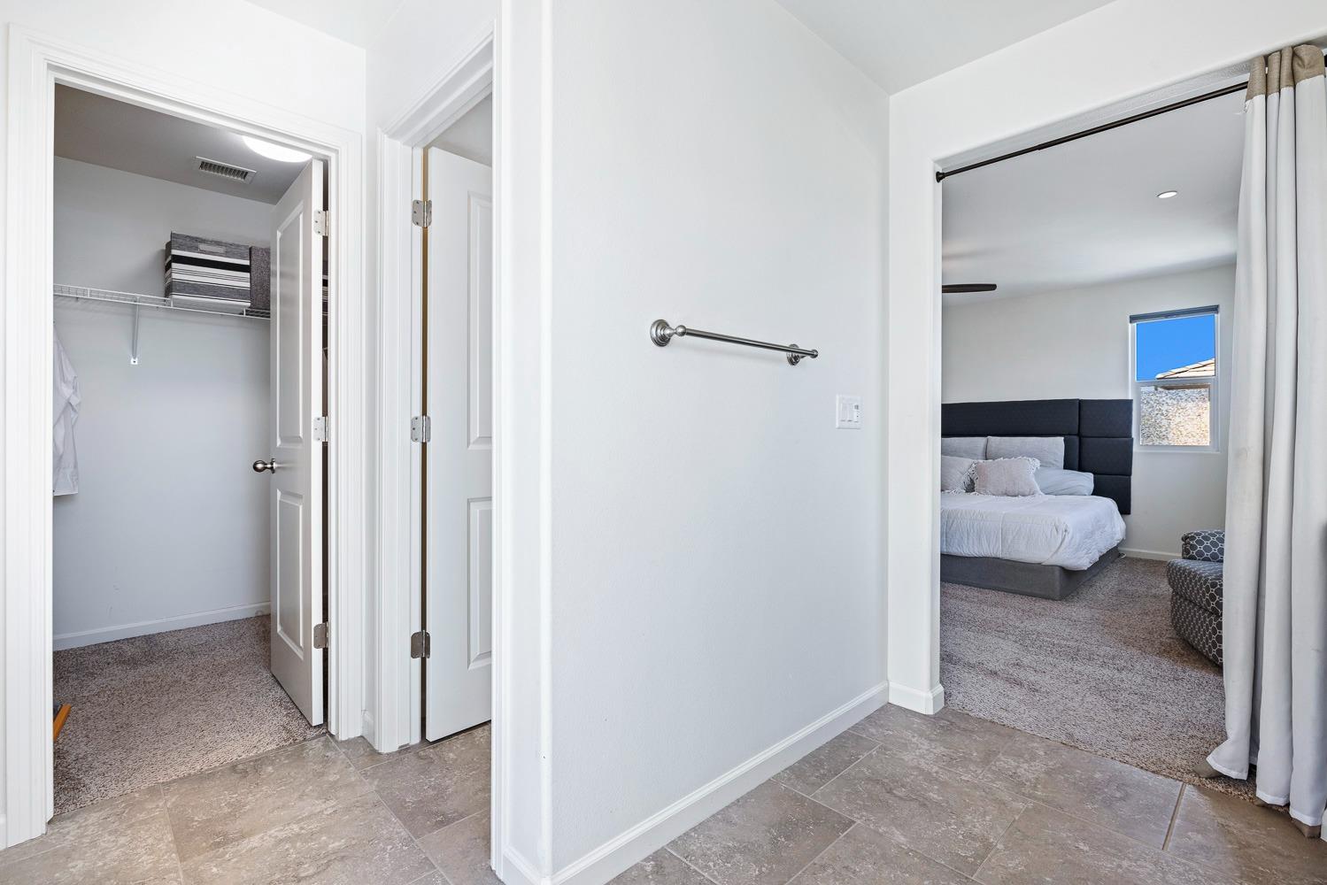 3606 Parkstone Way Clovis, CA 93619 - Photo 26 of 38 a bedroom with a bed and a view of en suite bathroom