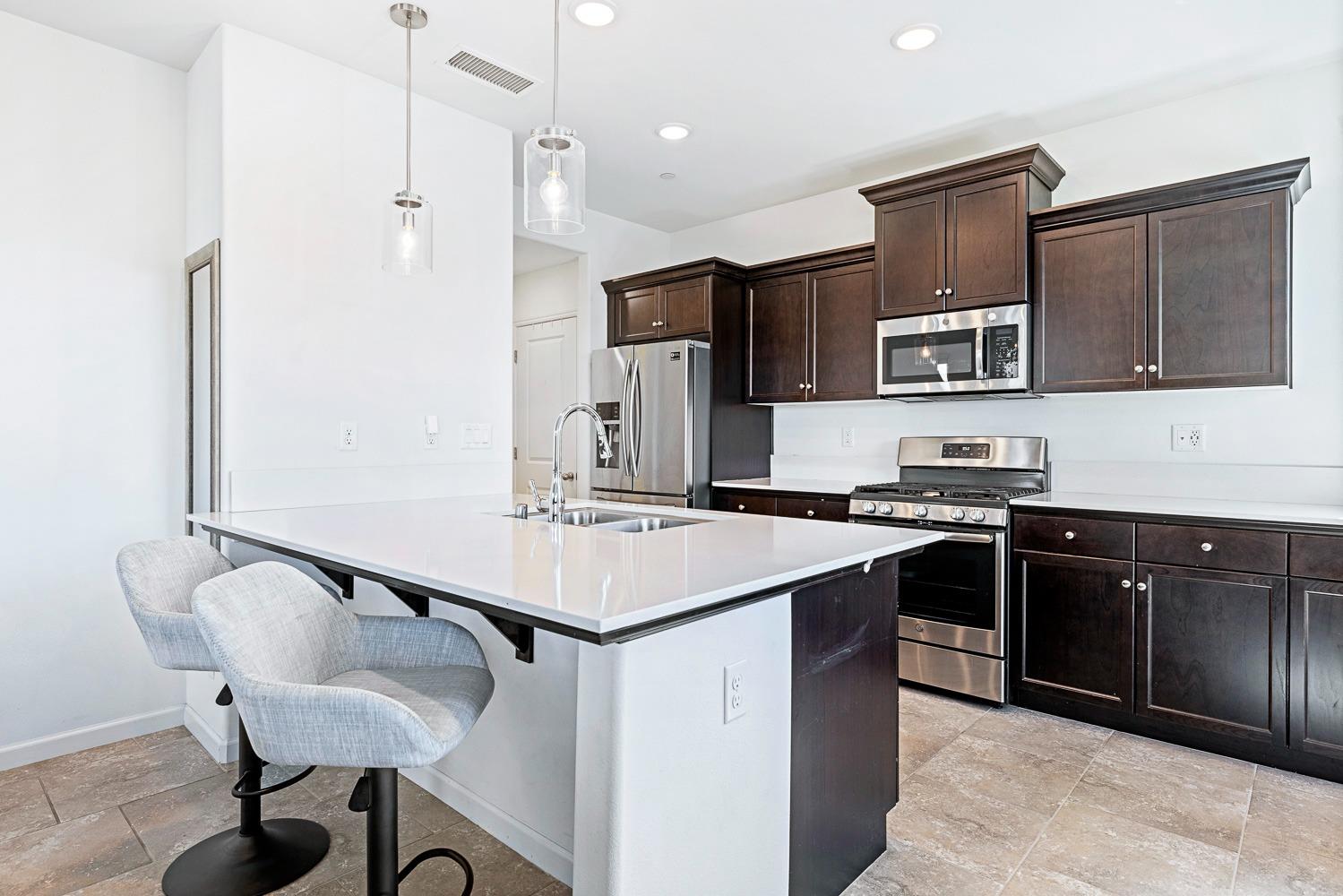 3606 Parkstone Way Clovis, CA 93619 - Photo 9 of 38 a kitchen with stainless steel appliances kitchen island a sink stove and refrigerator