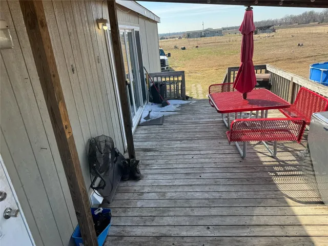 a view of a balcony with furniture and wooden floor
