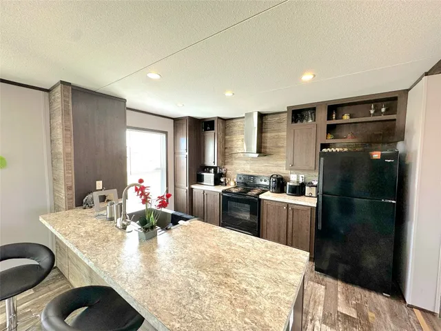 a kitchen with refrigerator and chairs