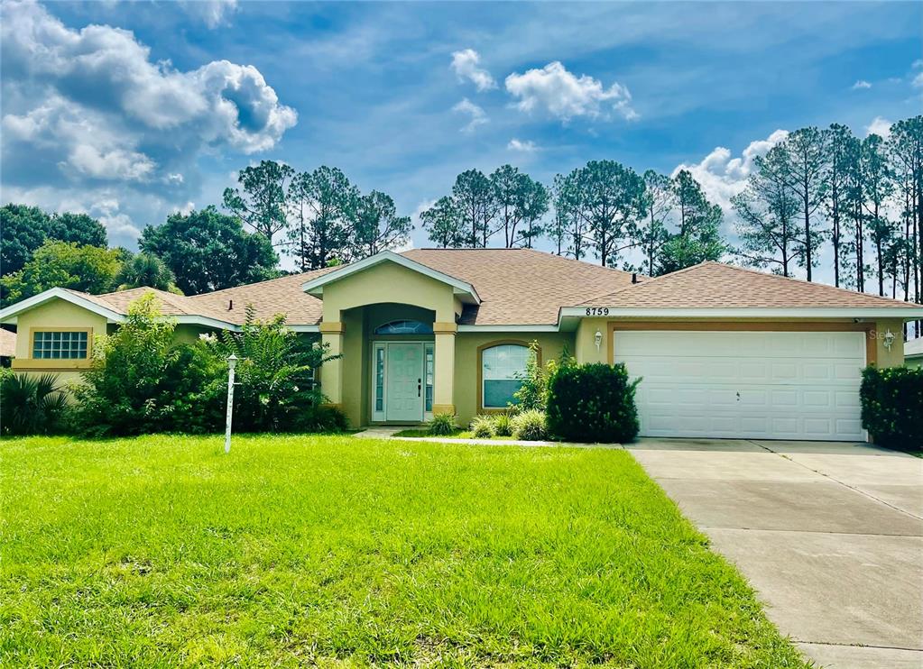 8759 Southwest 52nd Court Ocala, FL 34476 - Photo 1 of 20 a view of a house with a yard and garage