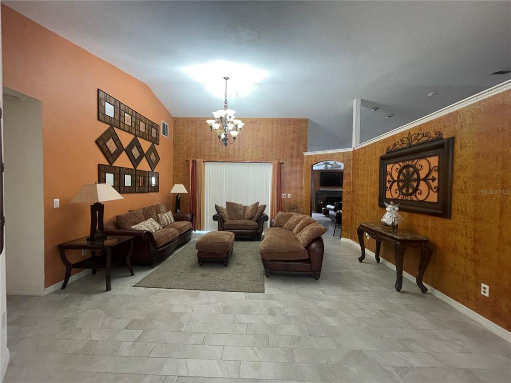 8759 Southwest 52nd Court Ocala, FL 34476 - Photo 3 of 20 a living room with furniture and a chandelier