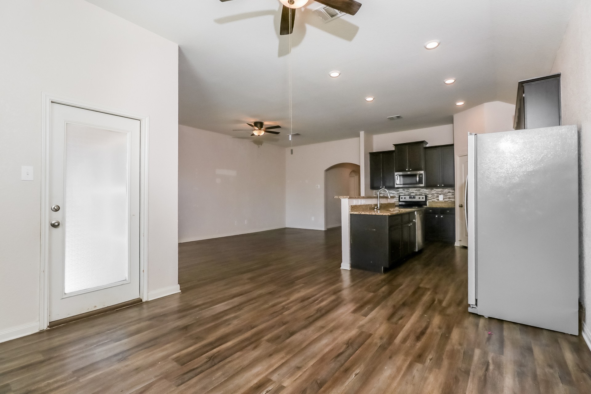 20017 Hubert R Humphrey Road Manor, TX 78653 - Photo 5 of 27 An open-concept living space integrates a well-appointed kitchen with warm wood-look flooring.